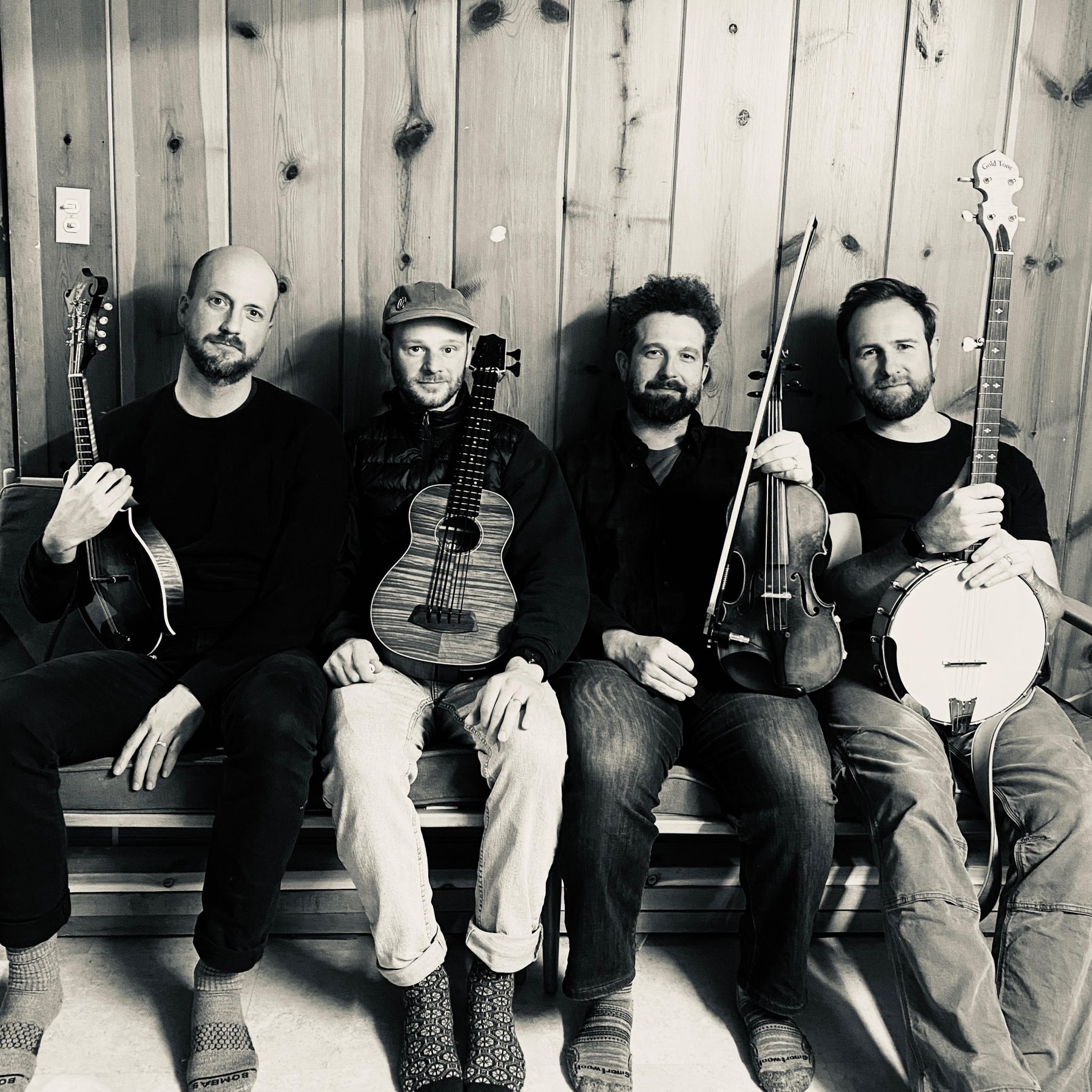 Father Leroy band members seated with mandolin, bass, fiddle and banjo
